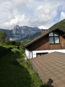 ein Haus mit einem Berg im Hintergrund in der Unterkunft Ferienwohnung BergTime in Weißenbach bei Liezen