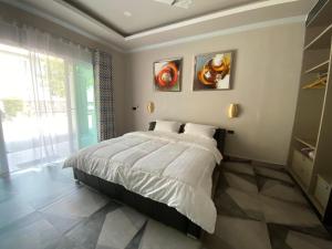 Ban Prasat的住宿－Sutalawadee Resort，卧室配有一张床,墙上挂有两幅画