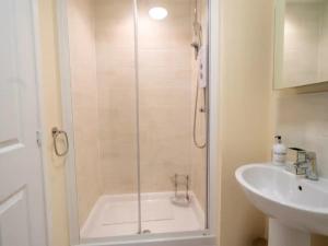 a shower with a glass door next to a sink at Pass the Keys Stylish 4 bedroom home in Nottingham