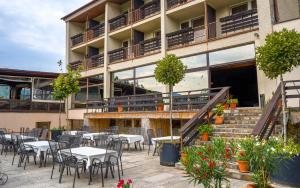 un patio avec des tables et des chaises en face d'un bâtiment dans l'établissement Grand Hotel rooms, à Spišské Tomášovce