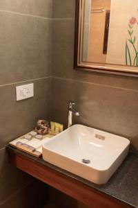 um lavatório branco na casa de banho com um espelho em Dutch Manor Boutique Hotel em Cochin
