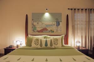 a bedroom with a bed and a painting on the wall at Dutch Manor Boutique Hotel in Cochin
