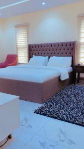 a bedroom with a large bed and a rug at David Davids in Lagos