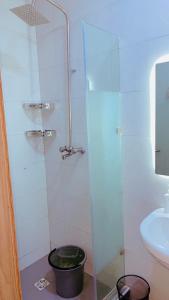 a bathroom with a glass shower with a bucket at David Davids in Lagos