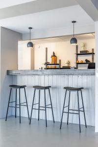 a kitchen with three bar stools in front of a counter at Hotel Aska in Reykjavík