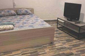 um quarto com uma cama e uma televisão de ecrã plano em Ανακαινισμένος ημιυπόγειος χώρος em Lárissa