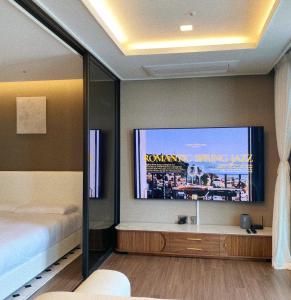 een slaapkamer met een bed en een flatscreen-tv bij SE1 3DH in Busan
