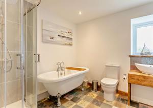 uma casa de banho com uma banheira, um WC e um lavatório. em Aqueduct Barn em Upwell