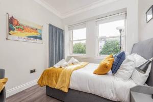 a bedroom with a bed with a yellow blanket on it at Stylish Apartment - Sleeps 4 - South Street St Andrews in St. Andrews