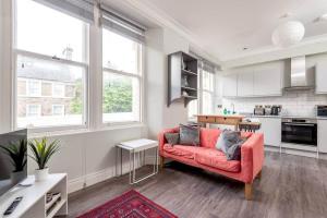 a living room with a red couch in a kitchen at Stylish Apartment - Sleeps 4 - South Street St Andrews in St. Andrews
