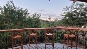 3 sillas sentadas en un balcón con vistas en Suíte família em Casa da Jaqueira, en Lençóis