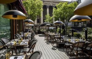 uma fila de mesas e cadeiras num pátio em Fauchon l'Hôtel Paris em Paris