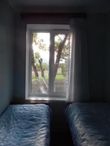 una ventana en un dormitorio con una cama delante en Ineza's Guest House, en Kazbegi