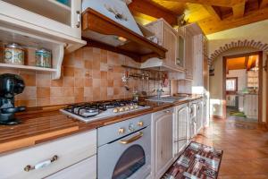a kitchen with white cabinets and a stove top oven at Happy Guest Apartments - Alpin Charme Colere in Colere