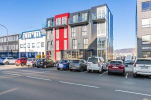 een parkeerplaats met auto's voor gebouwen bij Hotel Aska in Reykjavík
