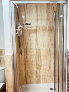 a shower with a glass door in a bathroom at Relax in this cosy Haven near Glenfield and Royal Infirmary Hospitals in Leicester