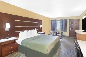 a hotel room with a bed and a television at Days Inn by Wyndham Fayetteville in Fayetteville