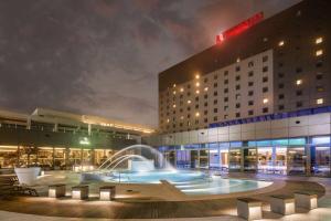 a hotel with a fountain in front of a building at Ramada Plaza by Wyndham Bucharest Convention Center in Bucharest