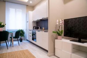 cocina con armarios blancos y TV de pantalla plana en Arezzo 38, en Roma