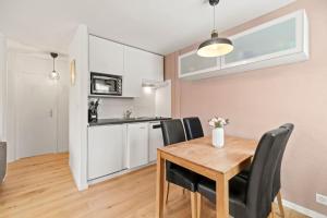 cocina y comedor con mesa de madera y sillas en Appartement calme et accueillant à Charmey en Charmey