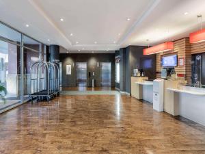 a large room with a lobby with wooden floors and a large window at ibis Sydney Darling Harbour in Sydney