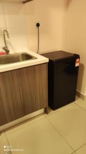 a kitchen with a sink and a small refrigerator at HB1511-Cyberjaya-Netflix-Wifi-Parking-Pool , 3089 in Cyberjaya