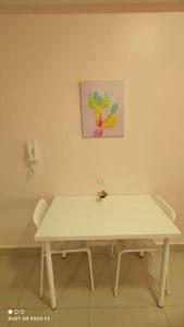einen weißen Tisch in einem Zimmer mit einem Gemälde an der Wand in der Unterkunft HB1511-Cyberjaya-Netflix-Wifi-Parking-Pool , 3089 in Cyberjaya