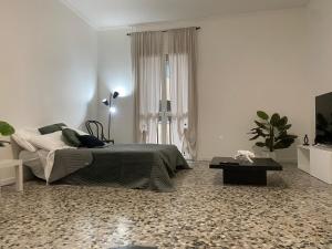 a white bedroom with a bed and a table at Short Stay Pavia nuovo in città in Pavia