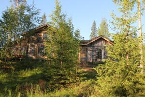 an old log cabin in the woods with trees at Valonranta Cottage in Kalmari