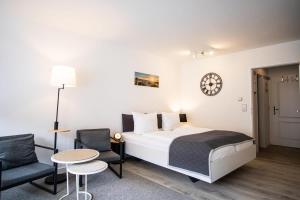 una camera da letto con un letto, un tavolo e delle sedie di Kompass Sylt a Westerland