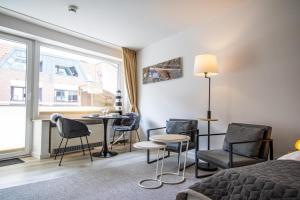 una camera da letto con un letto, sedie e un tavolo di Kompass Sylt a Westerland