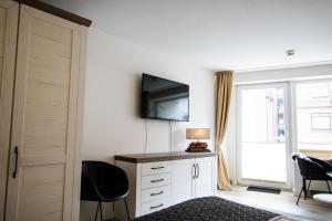 una camera da letto con scrivania, TV e finestra di Kompass Sylt a Westerland