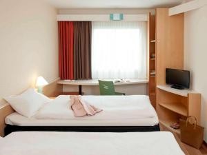 a hotel room with a bed and a window at ibis Berlin City Potsdamer Platz in Berlin