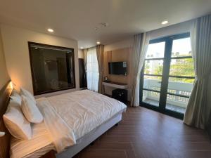 sypialnia z łóżkiem i dużym oknem w obiekcie Tanya Phu Quoc Hotel w Duong Dong