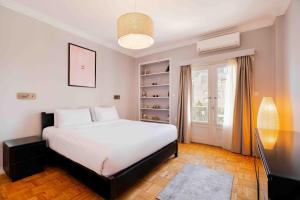 Un dormitorio con una gran cama blanca y una ventana en Brassbell l Cozy 1 BR apartment in Zamalek en El Cairo