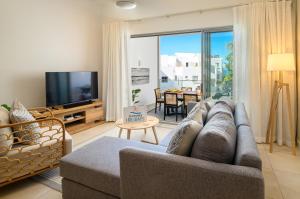 a living room with a couch and a television at Ocean Grand Gaube with LOV in Grand Gaube