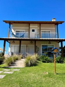 una casa en la playa con un cielo azul en Santinho Ocean View House, en Florianópolis