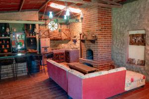 sala de estar con chimenea de ladrillo y sofá en Cabaña Romantica en Arandas