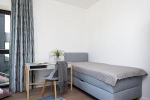 1 dormitorio con cama y escritorio en Sea View Family Apt in Unique Kalaranna District en Tallin