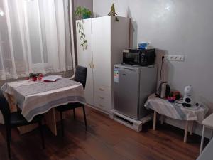 a kitchen with a table and a microwave on top of a refrigerator at Pilve apartment in Võru