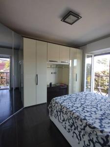 ein Schlafzimmer mit einem Bett mit einer blau-weißen Decke in der Unterkunft Bilocale luminoso e accogliente zona Marche in Mailand