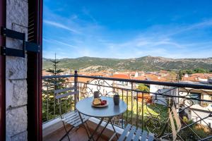 a table with a plate of food on a balcony at Το Πέτρινο in Kalavrita