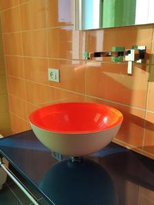 a red sink sitting on a counter in a bathroom at Bilocale luminoso e accogliente zona Marche in Milan +35 photos