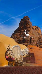 a group of tents in the desert with a mountain at RUM JOHARH lUXURY CAMP in Wadi Rum