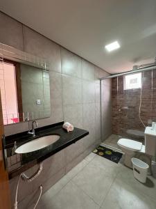 a bathroom with a sink and a toilet and a mirror at HOSTEL DA LAPINHA in Santana do Riacho