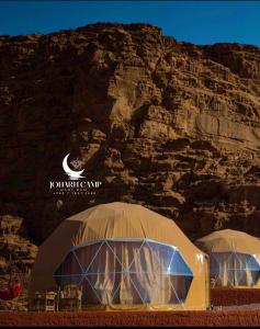 two domes with chairs in front of a mountain at RUM JOHARH lUXURY CAMP in Wadi Rum