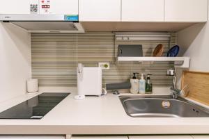 a small kitchen with a sink and a refrigerator at Stay Seoul N Myeongdong in Seoul