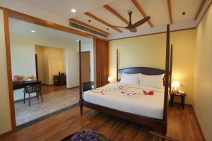 una camera con un grande letto e una scrivania di Misty Queen By Dimora Hotels a Kakkadampoyil