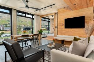 a living room with a television and a table with chairs at Neighbourgood 84 Harrington in Cape Town