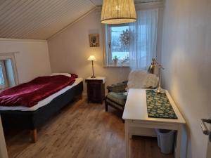 a bedroom with a bed and a couch and a window at Sällinge House - Cozy Villa with Fireplace and Garden close to Uppsala in Uppsala